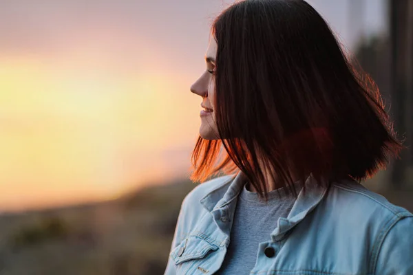 Attraktive junge rothaarige Frau mit Kurzhaarschnitt bei Sonnenuntergang im Wald. — Stockfoto