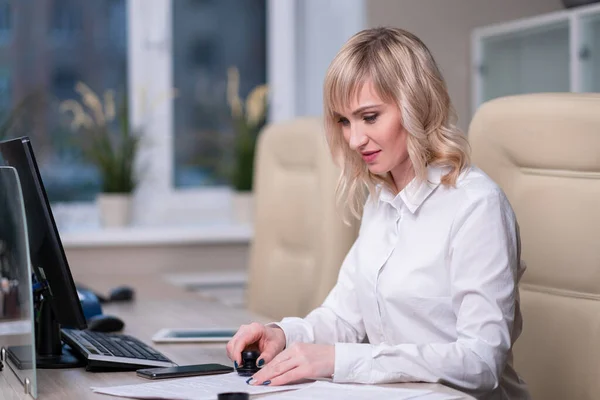 Portret van een jonge mooie vrouw, een kantoormedewerker in een wit shirt. Een vrouw werkt op een computer.. — Stockfoto