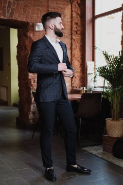 Bir restoranın içinde iş elbisesi içinde sakallı yakışıklı bir genç..