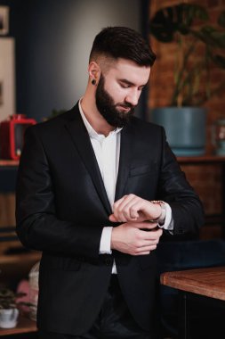 Bir restoranın içinde iş elbisesi içinde sakallı yakışıklı bir genç..