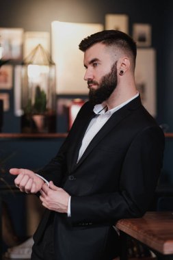 Bir restoranın içinde iş elbisesi içinde sakallı yakışıklı bir genç..