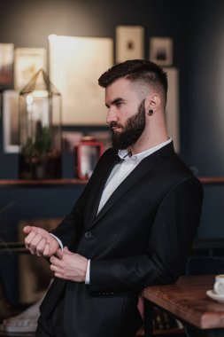Bir restoranın içinde iş elbisesi içinde sakallı yakışıklı bir genç..