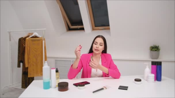 En kvinnlig bloggare online fotograferar en video om kosmetika. Visar och talar om läppstift. Stanna hemma. Självisolering och karantän. — Stockvideo