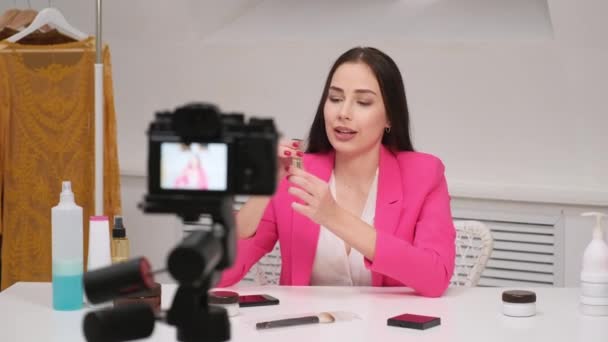 Uma blogueira online filma um vídeo sobre cosméticos. Mostra e fala sobre batom. Fica em casa. Auto-isolamento e quarentena . — Vídeo de Stock