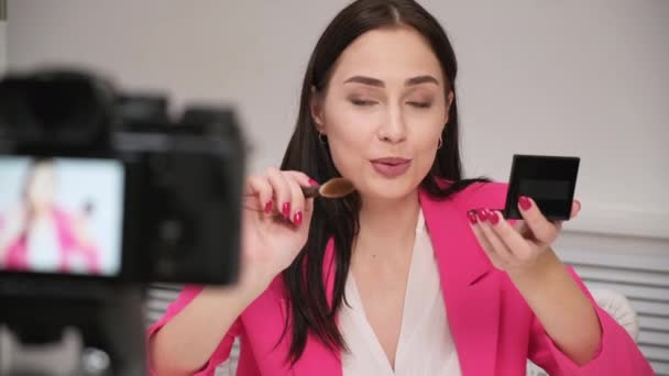 A beautiful young woman blogger in a pink jacket shoots a blog about cosmetics. Stay home. Self-isolation and quarantine. — Stock Video