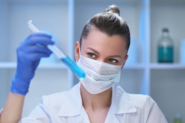 Kadın bir tıp bilimci laboratuarda çalışıyor. Spiker deneyler yapıyor, virüsten müzayedeyi geliştiriyor. Coronavirus covid-19.