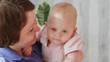 İki gülümseyen anne ve bir kız bebek. Anneler bebeği kollarına alır, sarılır ve öperler. Homoseksüel lezbiyen ailesi.