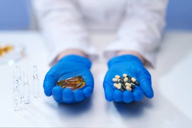 Doktorun elinde çok farklı haplar var. Bir avuç dolusu uyuşturucu. Vitaminler haplara karşı..