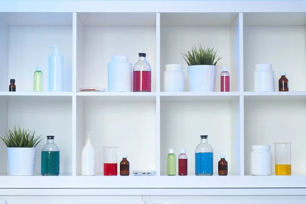 Πολλές διαφορετικές φιάλες και δοκιμαστικοί σωλήνες με υγρά διαφορετικών χρωμάτων στέκονται στο ράφι. Φαρμακείο. — Φωτογραφία Αρχείου