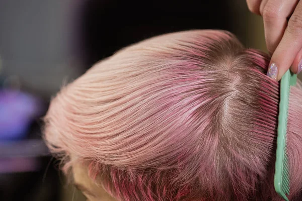 Coloriste coiffeur teint les cheveux d'une femme à un client en différentes couleurs . — Photo