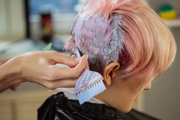 Coloriste coiffeur teint les cheveux d'une femme à un client en différentes couleurs . — Photo