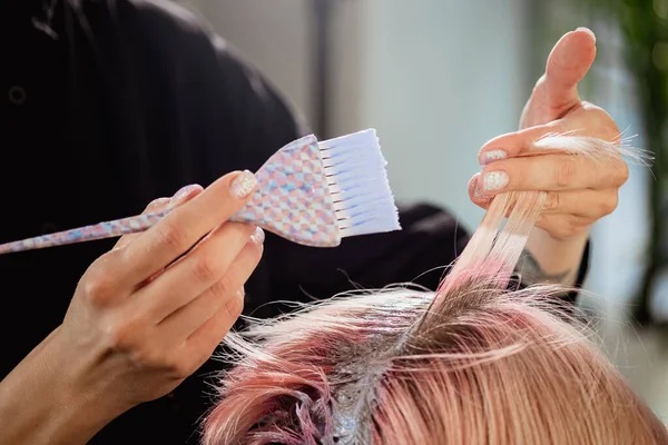 Frisör kolorist färgar håret på en kvinna till en kund i olika färger. — Stockfoto