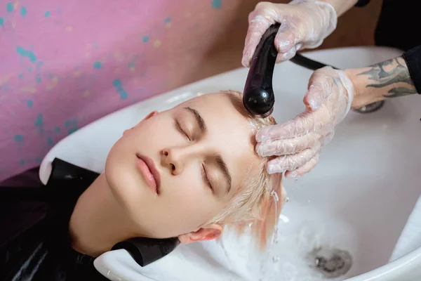 美容師は女性の頭をクライアントに洗います。着色. — ストック写真