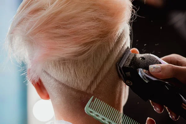 Machine de coiffure coupe femme cliente. Une coupe de cheveux courte, temple rasé et un dessin sur les cheveux . — Photo