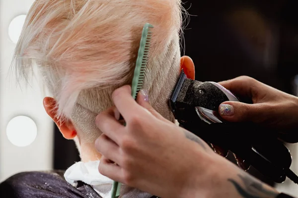 Máquina de cabeleireiro corta cliente mulher. Um corte de cabelo curto, templo raspado e um desenho no cabelo . — Fotografia de Stock