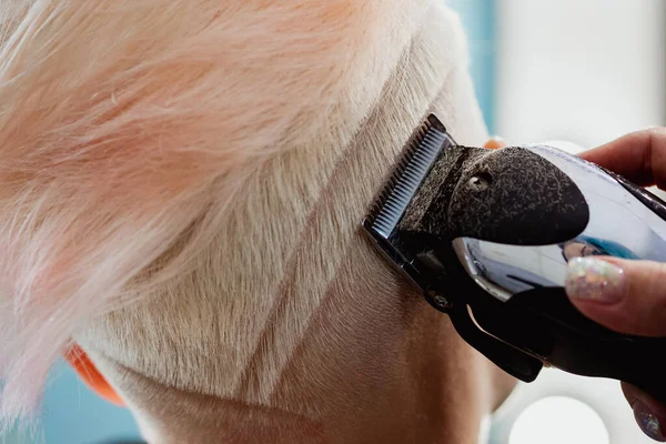 Máquina de cabeleireiro corta cliente mulher. Um corte de cabelo curto, templo raspado e um desenho no cabelo . — Fotografia de Stock