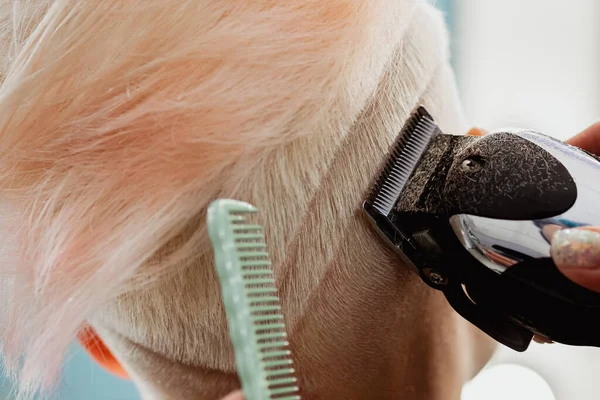 Máquina de cabeleireiro corta cliente mulher. Um corte de cabelo curto, templo raspado e um desenho no cabelo . — Fotografia de Stock