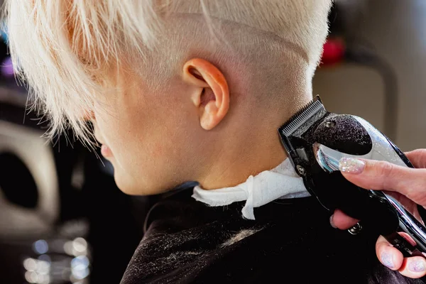 Máquina de cabeleireiro corta cliente mulher. Um corte de cabelo curto, templo raspado e um desenho no cabelo . — Fotografia de Stock