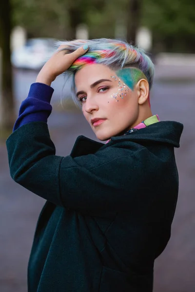 Egy fiatal, gyönyörű nő portréja, rövid hajjal és festett hajjal. Szürke fő szín és sárga, zöld, kék és vörös haj színe. — Stock Fotó