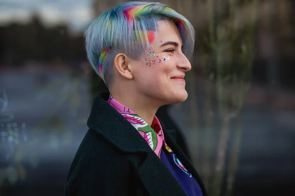 Portrait of a young beautiful woman in green coat with a short haircut and dyed hair. Grey main color and yellow, green, blue and red hair color. — Stock Photo, Image