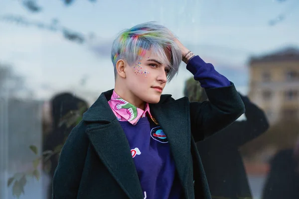 Retrato de una joven hermosa mujer en abrigo verde con un corte de pelo corto y cabello teñido. Color principal gris y color de pelo amarillo, verde, azul y rojo . —  Fotos de Stock