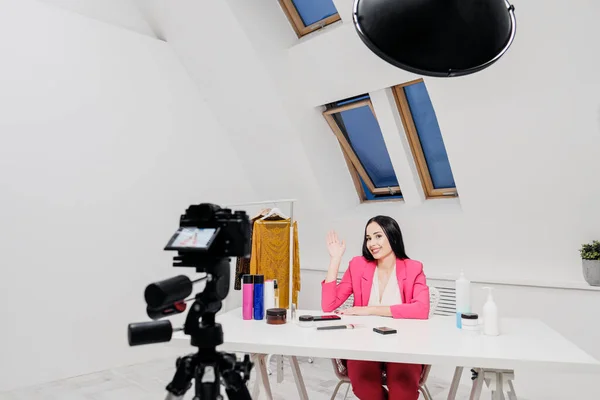 Ženské blogerky o kráse nahrávají video v bílé místnosti. Osvětlení a kamera na stativu. — Stock fotografie