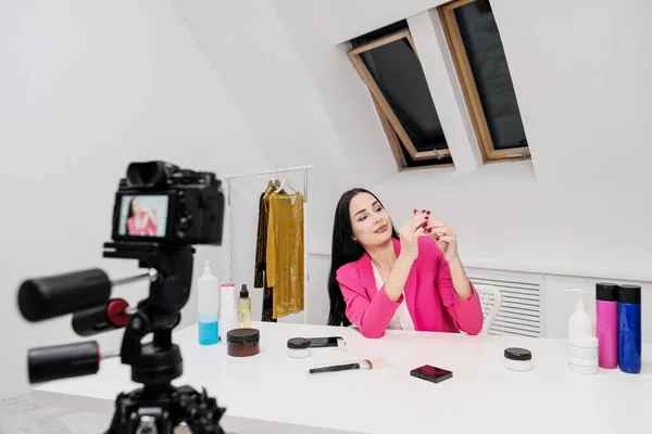 Ženské blogger on-line natáčí video o kosmetice. Zobrazuje a mluví o rtěnce. — Stock fotografie