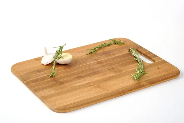 A wooden cutting board made of bamboo on a white background. A place for a product. Vegetables and greens and large salt. — Stock Photo, Image