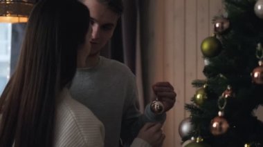 Akşamları genç bir çift evde bir Noel ağacı süsler. Taşaklı ol, sarıl ve gül. Noel Arifesi.