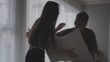 Genç bir çift, kadın ve erkek yatak odasında. Yatakta yuvarlanırlar, eğlenirler, yastıklarla kavga ederler ve sarılırlar. Aile akşamı.