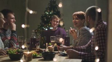 Arkadaşların evde yemek masasında tatil partisi veriyor. Noel 'i kutlayalım. Beş kişi yer, şampanya içer, konuşur ve güler..