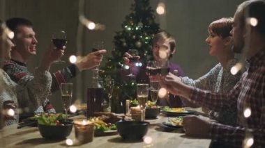 Arkadaşların evde yemek masasında tatil partisi veriyor. Noel 'i kutlayalım. Beş kişi yer, şampanya içer, konuşur ve güler..