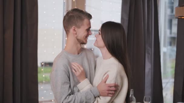 Retrato de una joven y hermosa pareja casada en casa sobre el fondo de una guirnalda y un árbol de Navidad . — Vídeo de stock