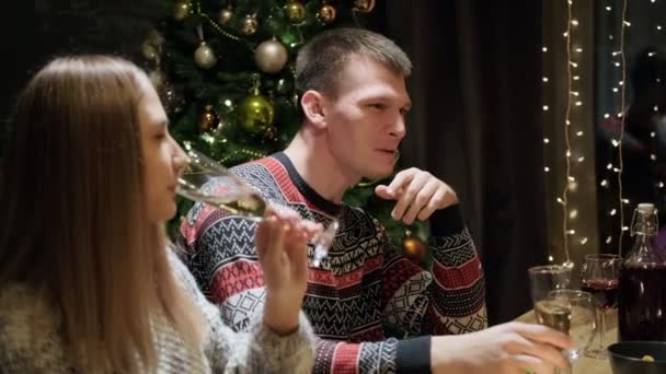 Amigos cena de fiesta en casa alrededor de la mesa. Celebra la Navidad. Cinco personas comen, beben champán, hablan y ríen . — Vídeo de stock