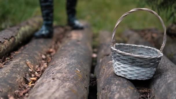 Un hombre con botas de goma toma una cesta para recoger setas . — Vídeo de stock