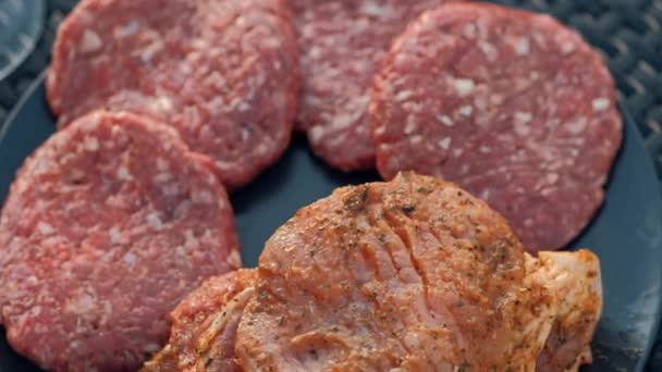 Grillsütő. Egy férfi hússzeletet és húsgombócot süt hamburgernek, megfordítja a húst fogóval.. — Stock videók
