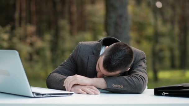 Mladý obchodník spí a probouzí se na pracovišti. — Stock video