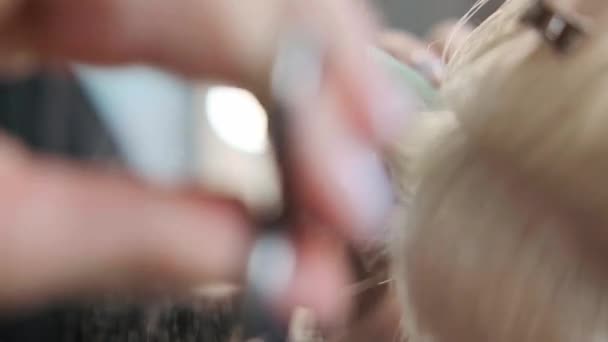 Le coiffeur coupe les cheveux teints femme cliente avec des ciseaux. Une coupe de cheveux courte pixie et des tempes rasées  . — Video