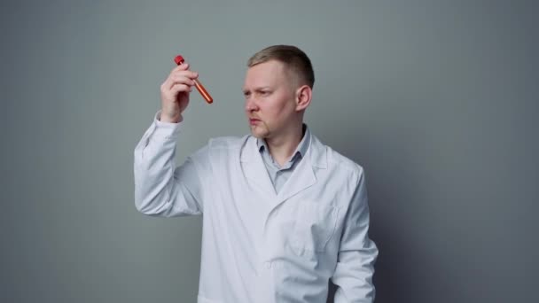 Kan testi. Erkek bir tıp çalışanı, üzerinde paciets kanı olan bir tüp tutuyor.. — Stok video