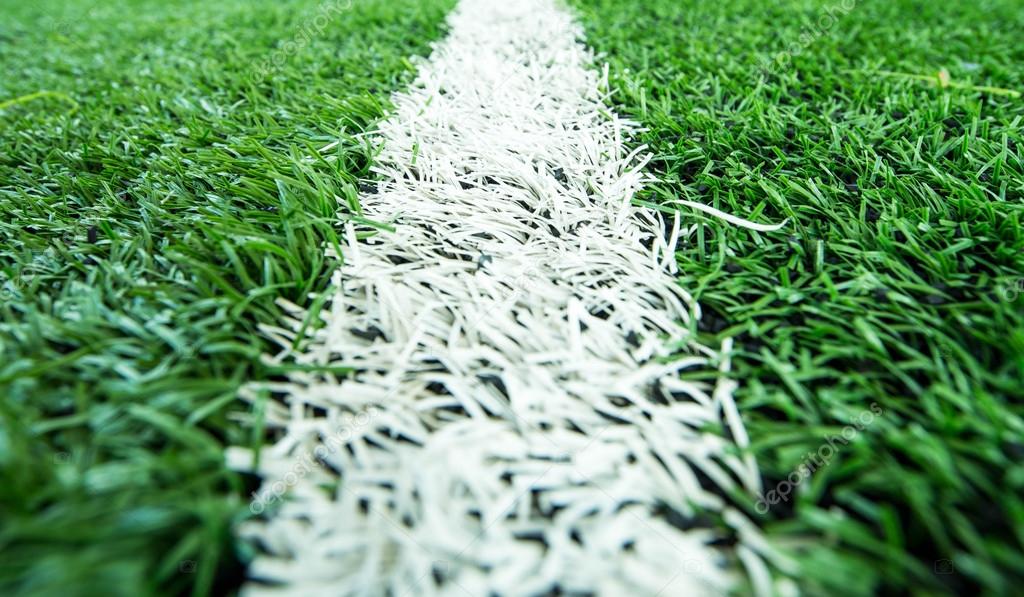 Closeup line on green soccer football field with player