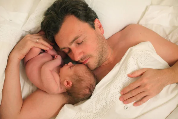 yatakta bebekli bir adam