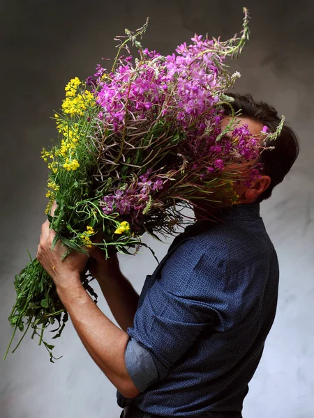 kır çiçekleri büyük bir buket tutan adam