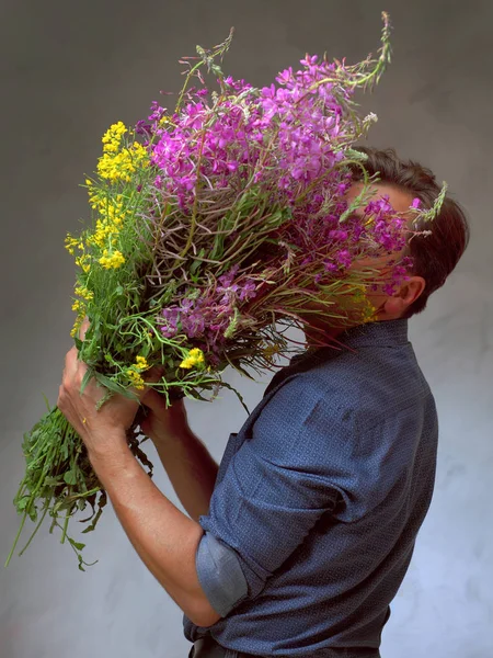 kır çiçekleri büyük bir buket tutan adam