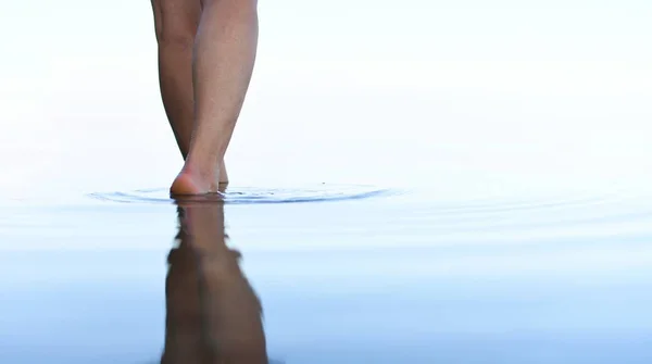 Feet of a beautiful girl walking on water, in a beautiful future.