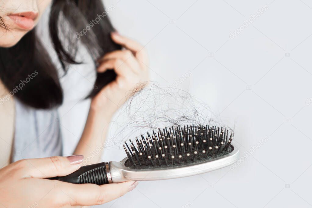 Asian woman brush her hair having problem with hair loss fall on comb