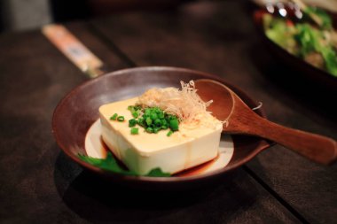 Japonya tofu doğranmış tabak bir geleneksel Japon restoranında ahşap masa üzerinde. Sağlıklı gıda. 
