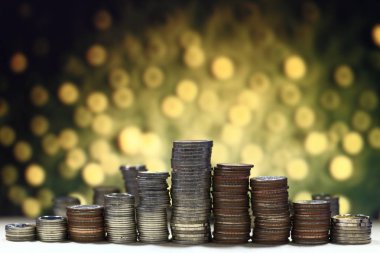 Piramit sikke sütun yüksek, Altın ışık arka plan üzerinde istifleme. Kaydetme ve finansal başarı kavramı adıma.