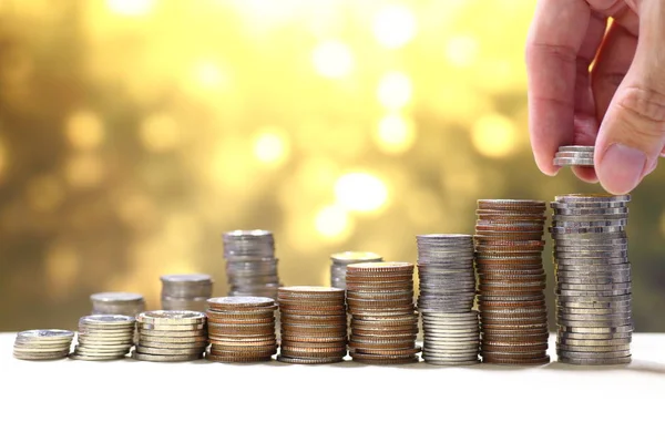 Högen av mynt stack på gyllene ljus bakgrund, finansiella framgångskoncept — Stockfoto