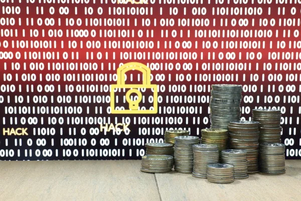 Digital economy. Coin stack with digital lock and hack ransom text in computer monitor screen in the background. Business, finance, ransomware and cyber security concept.