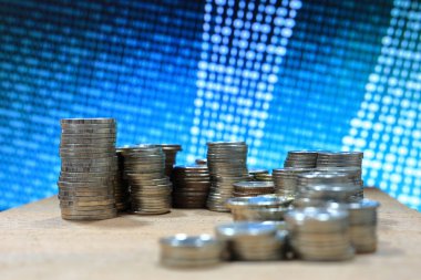 Dijital Ekonomi. Sikke yığını mavi ikili dijital sayılar arka plan ile. İş, finans ve kavram kaydetme.